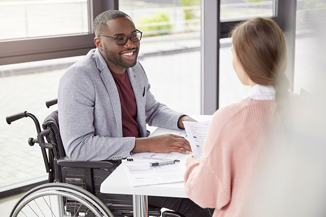 Man on a wheelchair talking with a woman